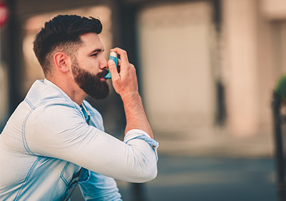 man using his inhaler