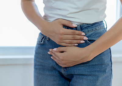 lady holding her bladder over her jeans